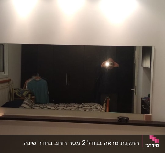 מראה גדולה על קיר עם השתקפות של חדר